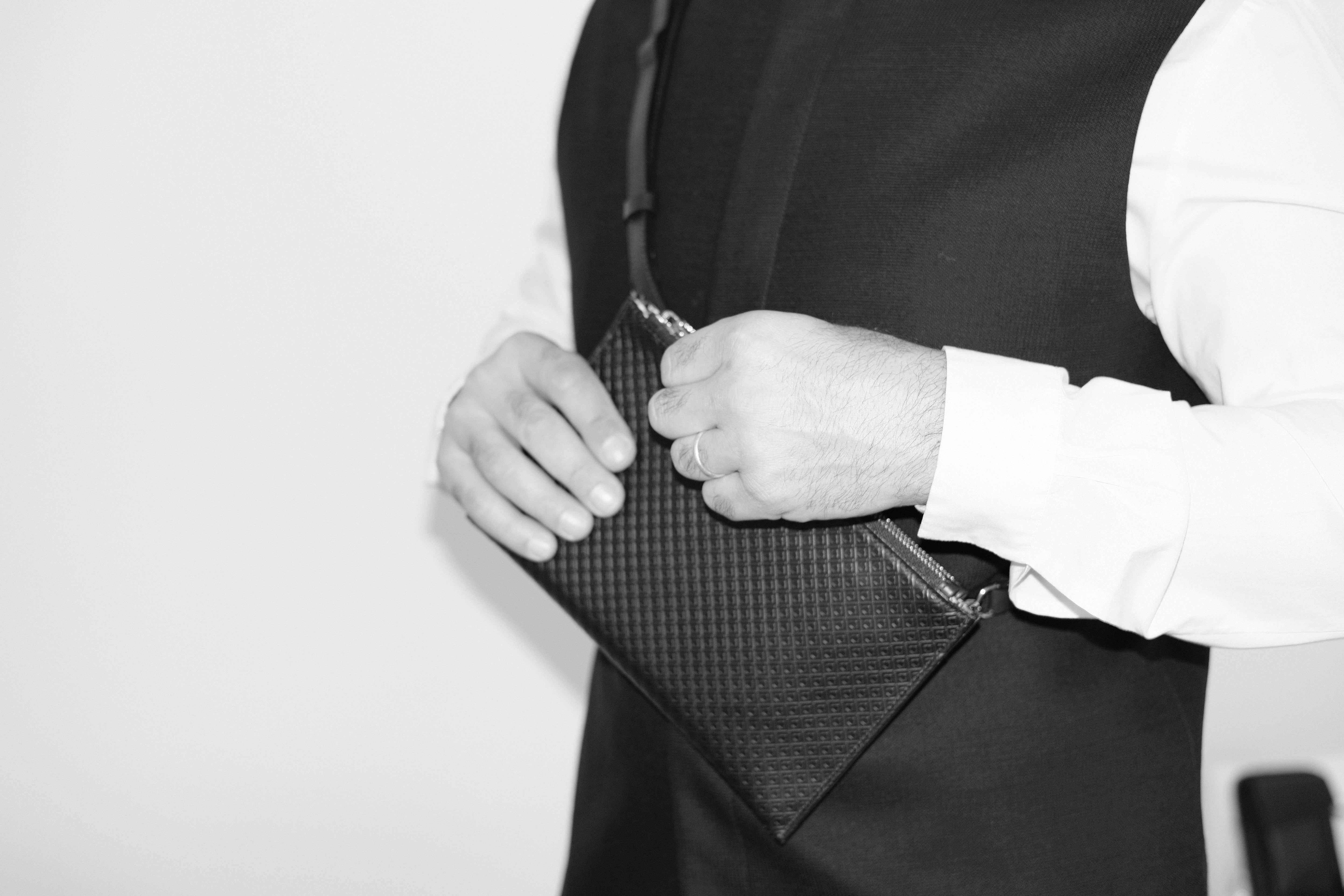 Stylish Person carrying the 3-2-1 Sorrento Crossbody, Pouch, and Bum Bag all-in-one, styled as a bum bag with double zippers. The side opening showcases its versatile and functional design, featuring premium Italian leather craftsmanship.