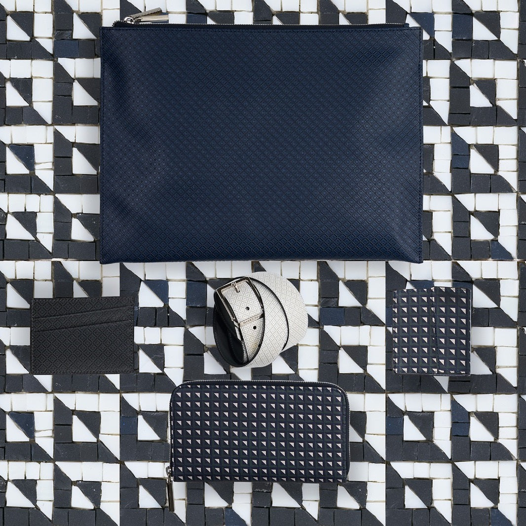 Document covers, wallets, accessories, and belts from the Great British Seaside collection arranged over a recreated mosaic pattern inspired by the original Roman villa mosaic floors in Pitney, Somerset.