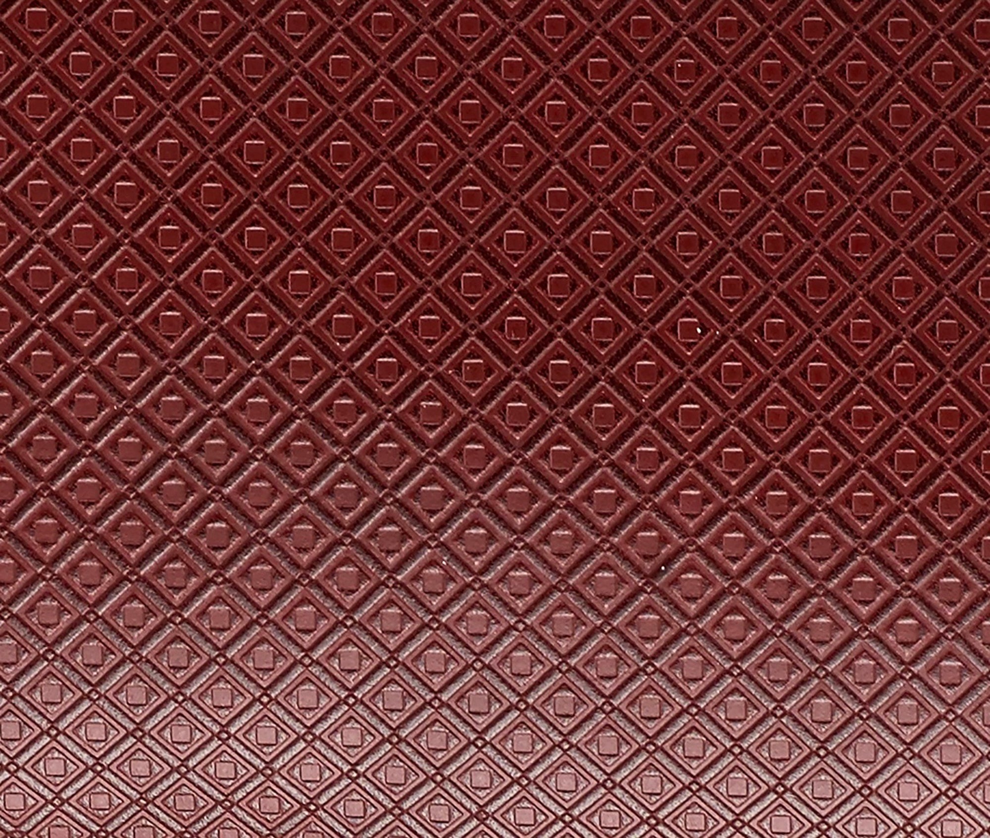 Close-up of MARK/GIUSTI’s signature embossed mosaic leather in Port Red, reflecting the textured layers inspired by historic Cosmati designs. This custom-developed leather captures the tactile essence of geometric mosaic patterns, combining artistry with modern craftsmanship.