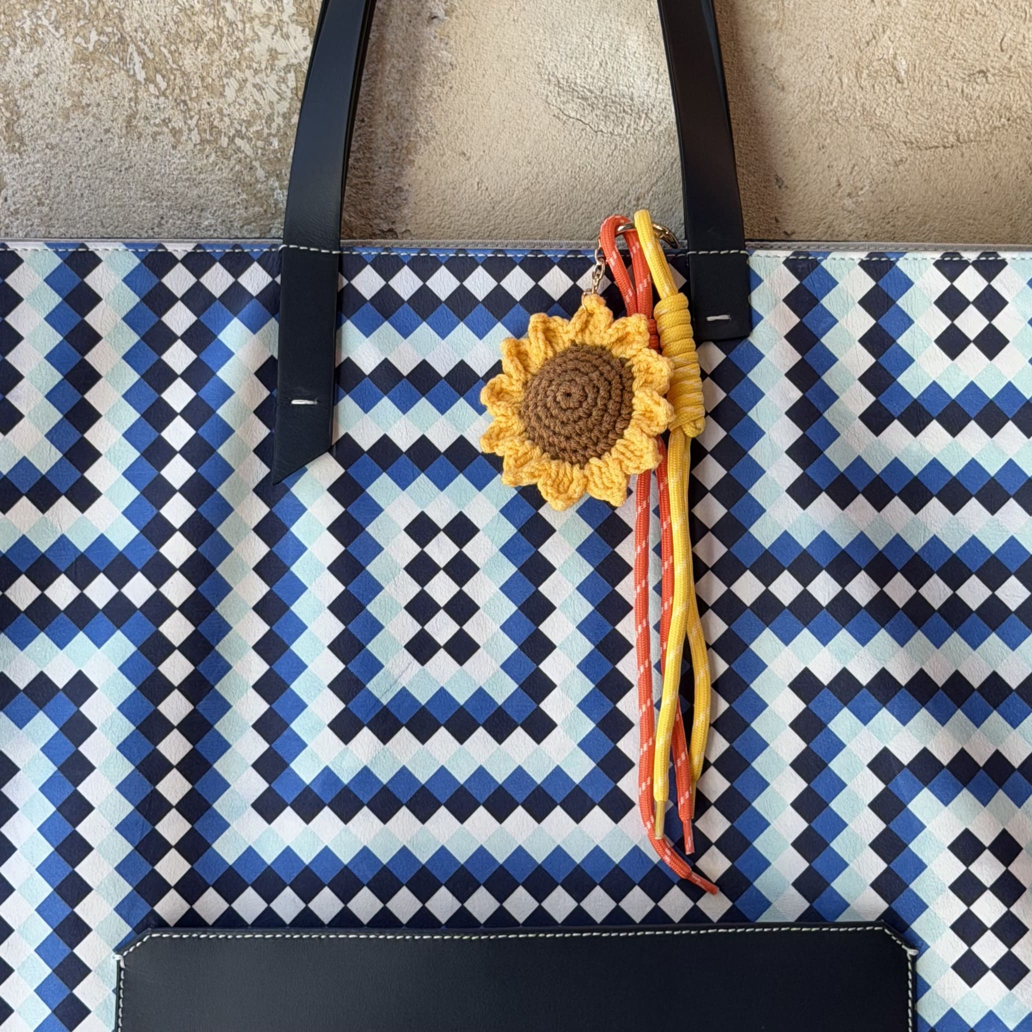 MARK / GIUSTI Signature CALA Oversized Tote triangular tote bag in leather with the new Alhambra Exaggerated Mosaic pattern in shades of blue featuring a solid Navy front pocket and handles and sperate sunflower charm.