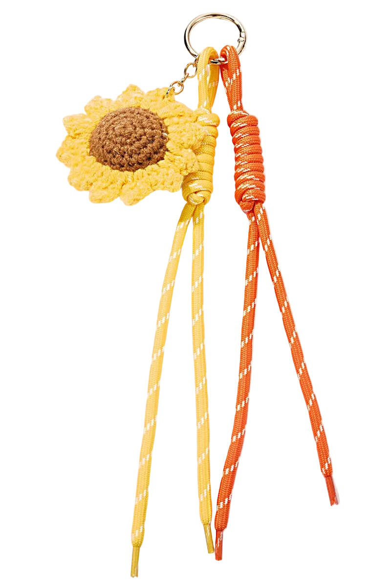 MARK / GIUSTI Sunflower-shaped crochet keychain with two colorful ribbons on a white background