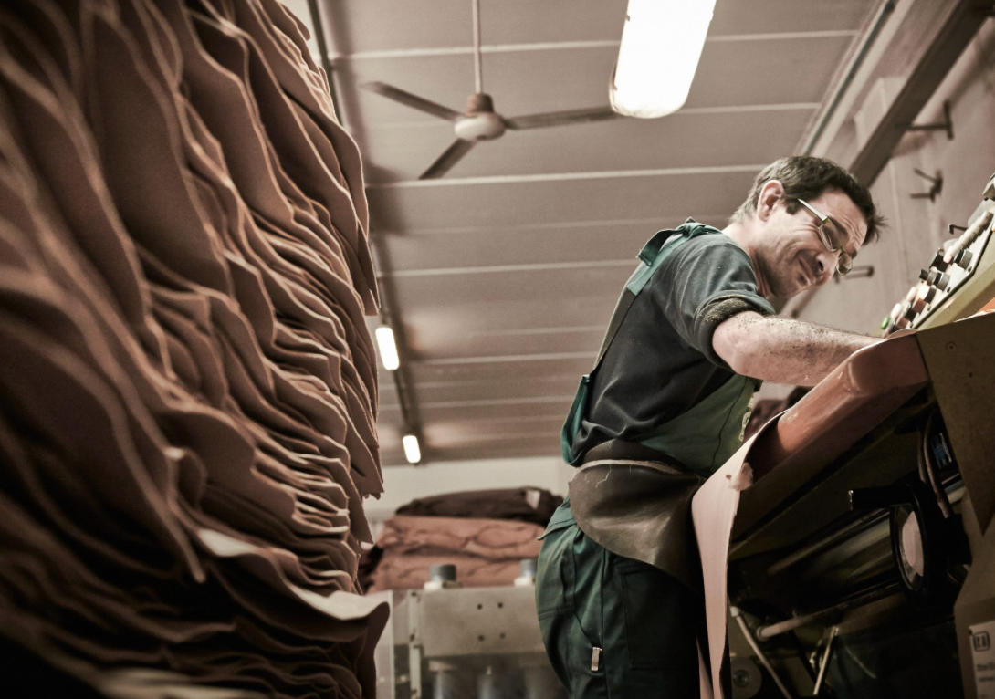 Artisans at MARK / GIUSTI’s vegetable-tanned leather tannery inspecting leather to ensure adherence to sustainable practices, featured in the Sustainability as Standard section.